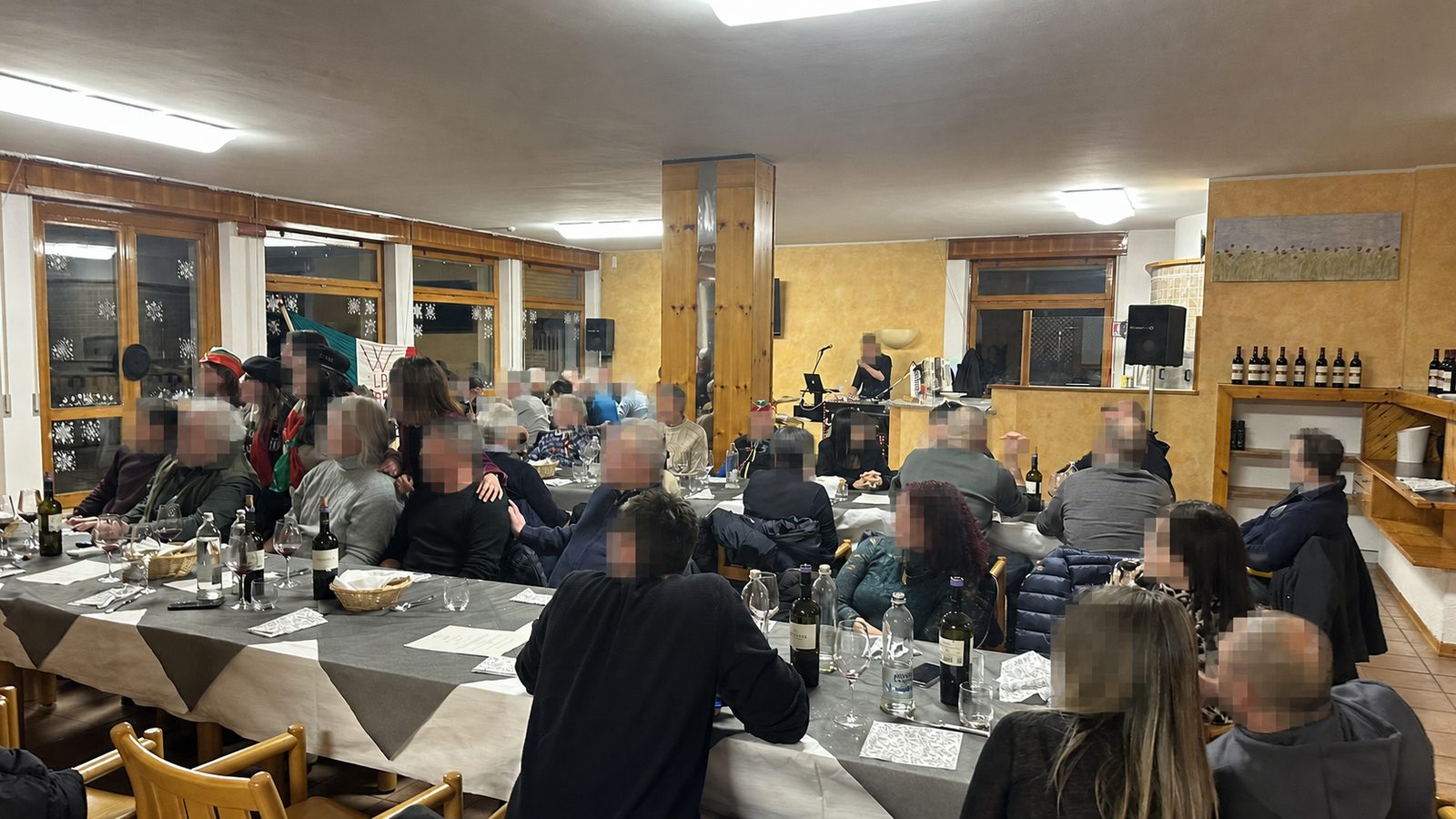 Serata con ospiti nella sala ristorante e volti pixelati