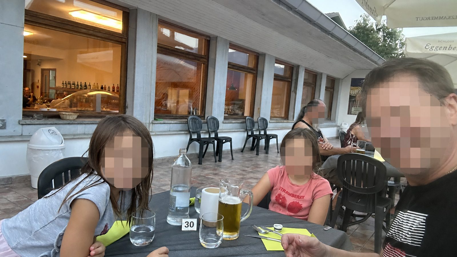 Famiglia sulla terrazza dell'hotel con volti fortemente pixelati